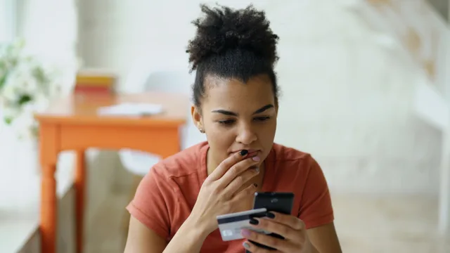 Young woman shopping online using a smartphone and credit card indoors. How to run a subscription commerce operating workflow without weekly firefighting