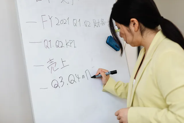 Woman in business attire writing financial notes on whiteboard in office. How to run subscription commerce operations that scale cleanly
